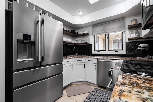 kitchen with a sink, open shelves, tasteful backsplash, and stainless steel appliances