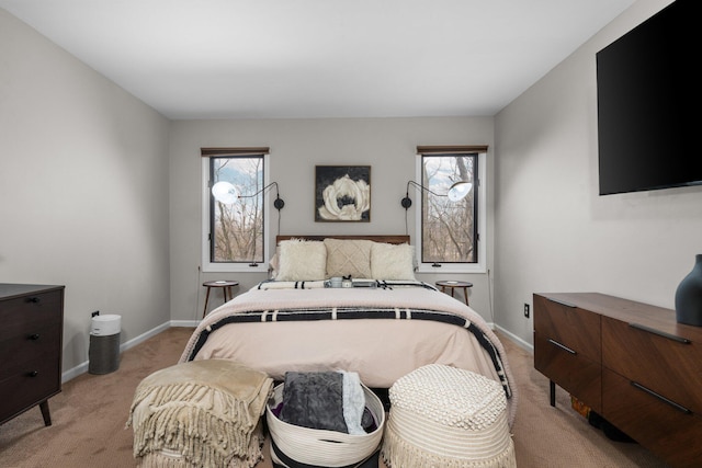 bedroom with light carpet, multiple windows, and baseboards