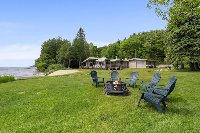 6863 Crystal Dr, Beulah, MI 49617 - view of grassy yard featuring an outdoor fire pit and a water view