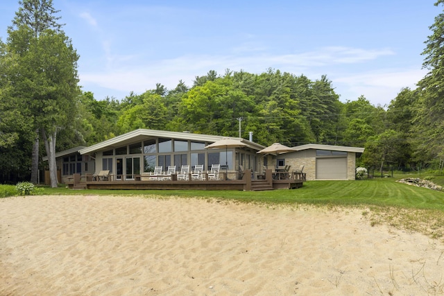 6863 Crystal Dr, Beulah, MI 49617 - mid-century modern home featuring a sunroom, a deck, an attached garage, dirt driveway, and a front lawn