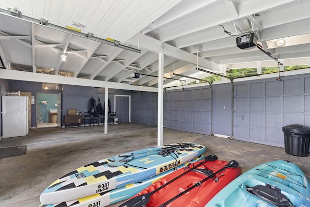 6863 Crystal Dr, Beulah, MI 49617 - garage featuring a garage door opener and freestanding refrigerator