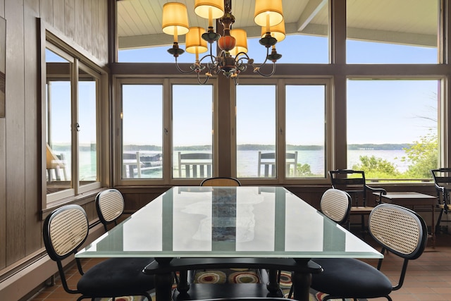 6863 Crystal Dr, Beulah, MI 49617 - tiled dining area with a water view, plenty of natural light, a chandelier, and wood ceiling