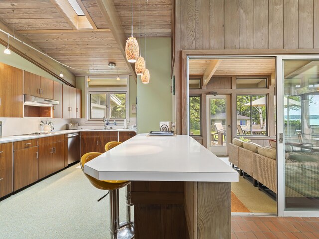6863 Crystal Dr, Beulah, MI 49617 - kitchen featuring a wooden ceiling with exposed beams, stainless steel dishwasher, light countertops, brown cabinets, and under cabinet range hood