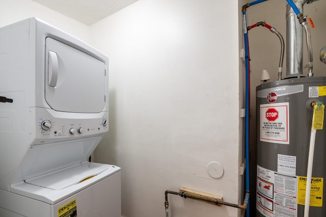 laundry room featuring water heater, laundry area, and stacked washer / drying machine