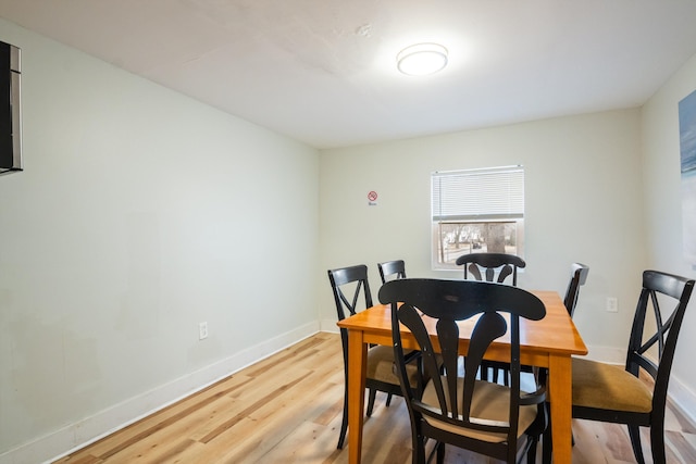 dining space featuring light wood-type flooring and baseboards