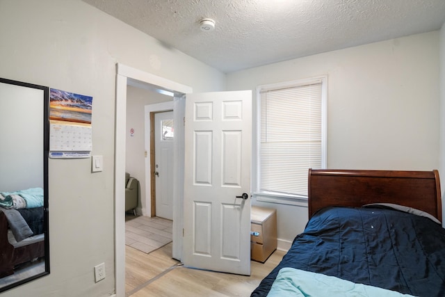 bedroom with light wood-style floors and a textured ceiling