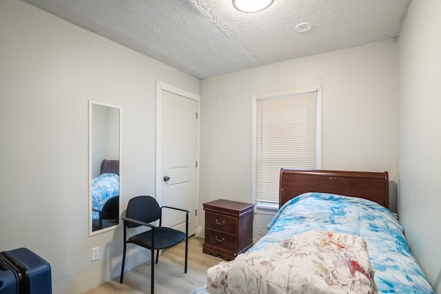 bedroom featuring a textured ceiling and light wood-type flooring