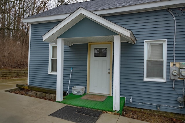 property entrance featuring a shingled roof