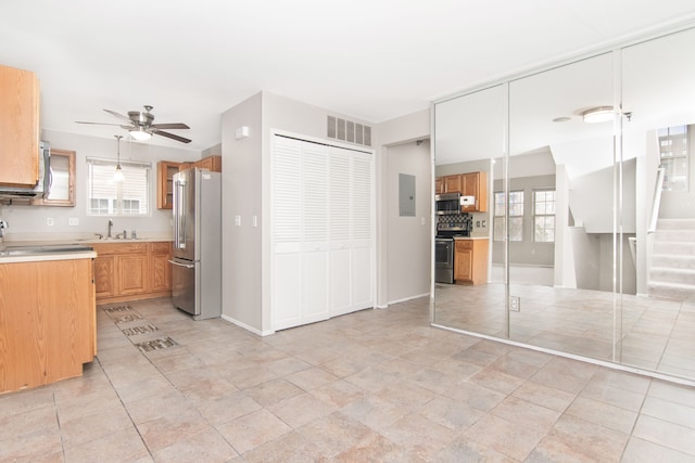 kitchen featuring stainless steel appliances, light countertops, visible vents, a ceiling fan, and a sink