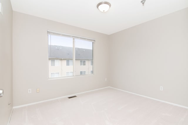 unfurnished room with light carpet, baseboards, and visible vents