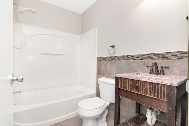 bathroom with toilet, a wainscoted wall, tile patterned floors, tile walls, and shower / bathing tub combination