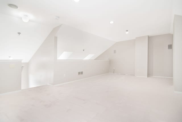 additional living space with lofted ceiling with skylight, visible vents, carpet floors, and baseboards