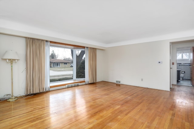 empty room featuring visible vents and light wood-style floors