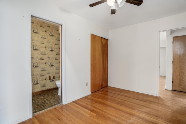 unfurnished bedroom featuring baseboards, ceiling fan, a closet, and light wood-style floors