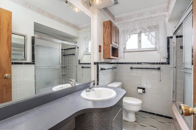 full bathroom featuring tile patterned flooring, a wainscoted wall, tile walls, and toilet