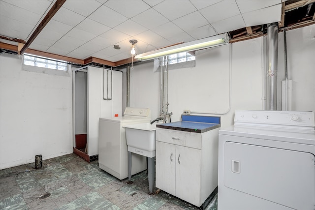 clothes washing area featuring laundry area, light floors, and separate washer and dryer