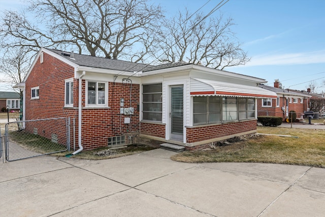 bungalow-style home featuring fence and brick siding