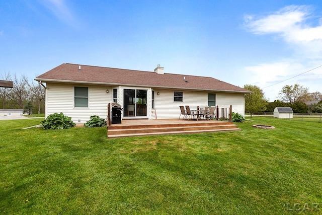 back of house with an outbuilding, a yard, a chimney, and a wooden deck