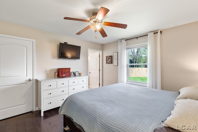 bedroom with a ceiling fan and dark wood-style flooring