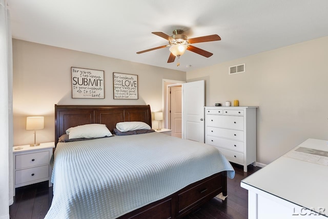 bedroom with ceiling fan, dark wood finished floors, visible vents, and baseboards