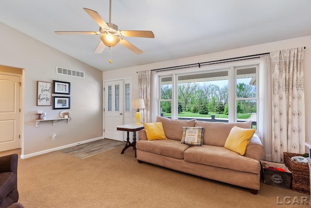 living area with visible vents, carpet flooring, vaulted ceiling, ceiling fan, and baseboards