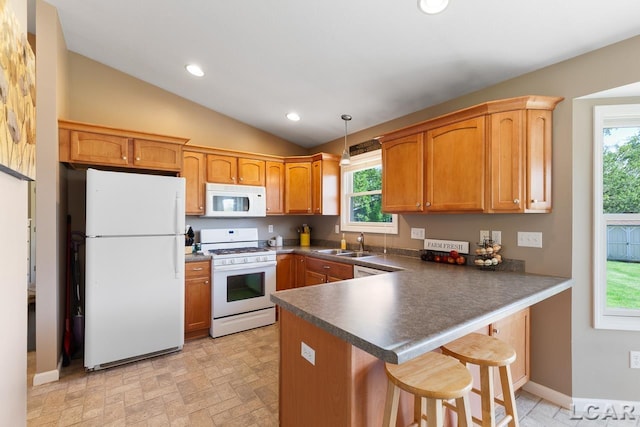 kitchen featuring dark countertops, recessed lighting, a sink, white appliances, and a peninsula