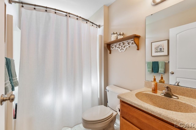 bathroom with curtained shower, vanity, and toilet