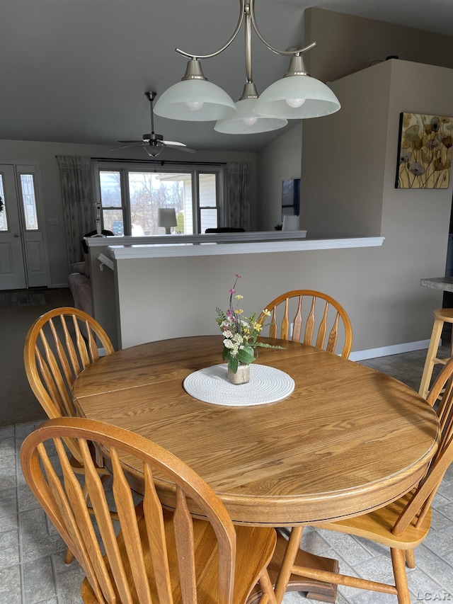 dining area with ceiling fan and baseboards