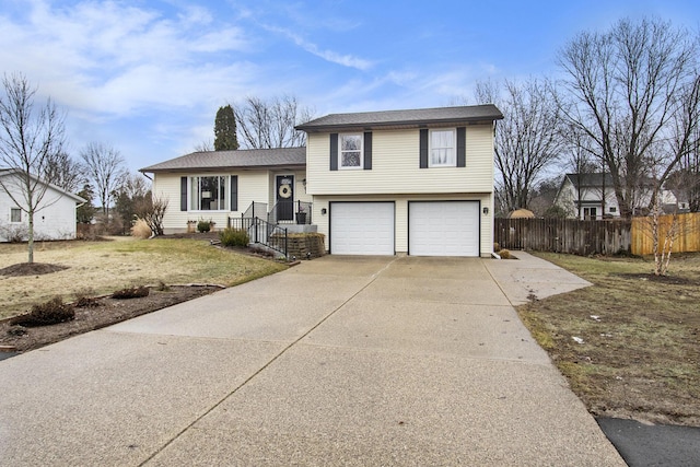 split level home featuring driveway, an attached garage, and fence