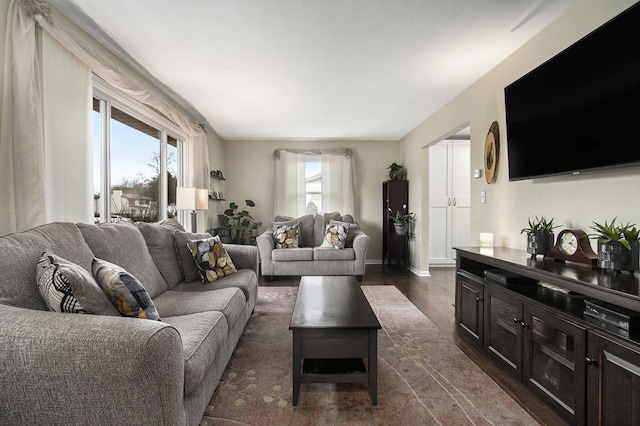 living area with dark wood-type flooring and baseboards