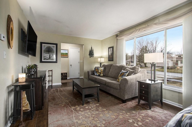 living area with dark wood-type flooring and baseboards