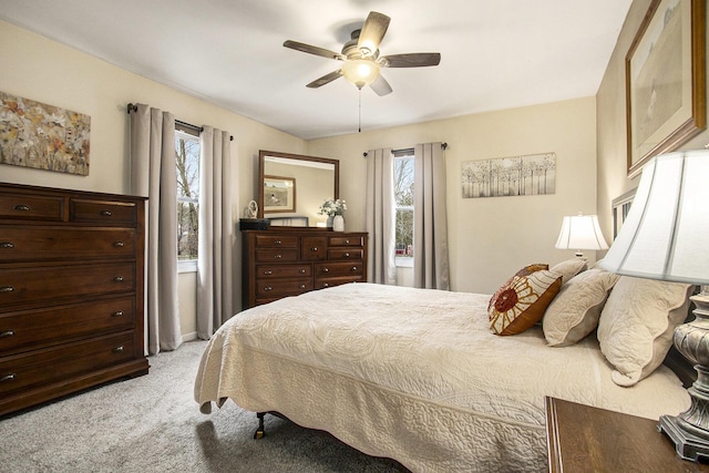 bedroom featuring light carpet, multiple windows, and a ceiling fan