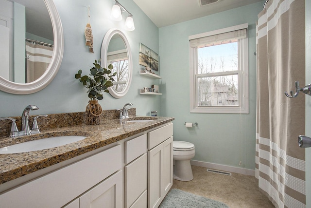 bathroom featuring toilet, a sink, visible vents, and baseboards