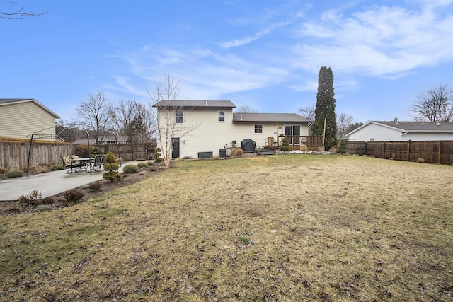 back of property featuring a deck, a patio, a fenced backyard, central air condition unit, and a lawn