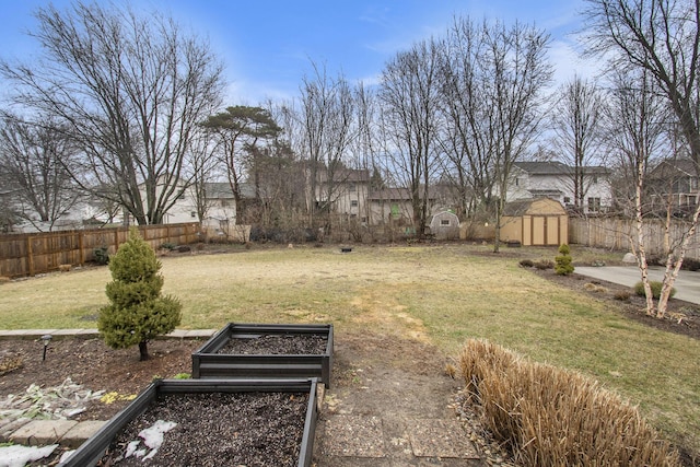 view of yard with a fenced backyard, a vegetable garden, an outdoor structure, and a shed