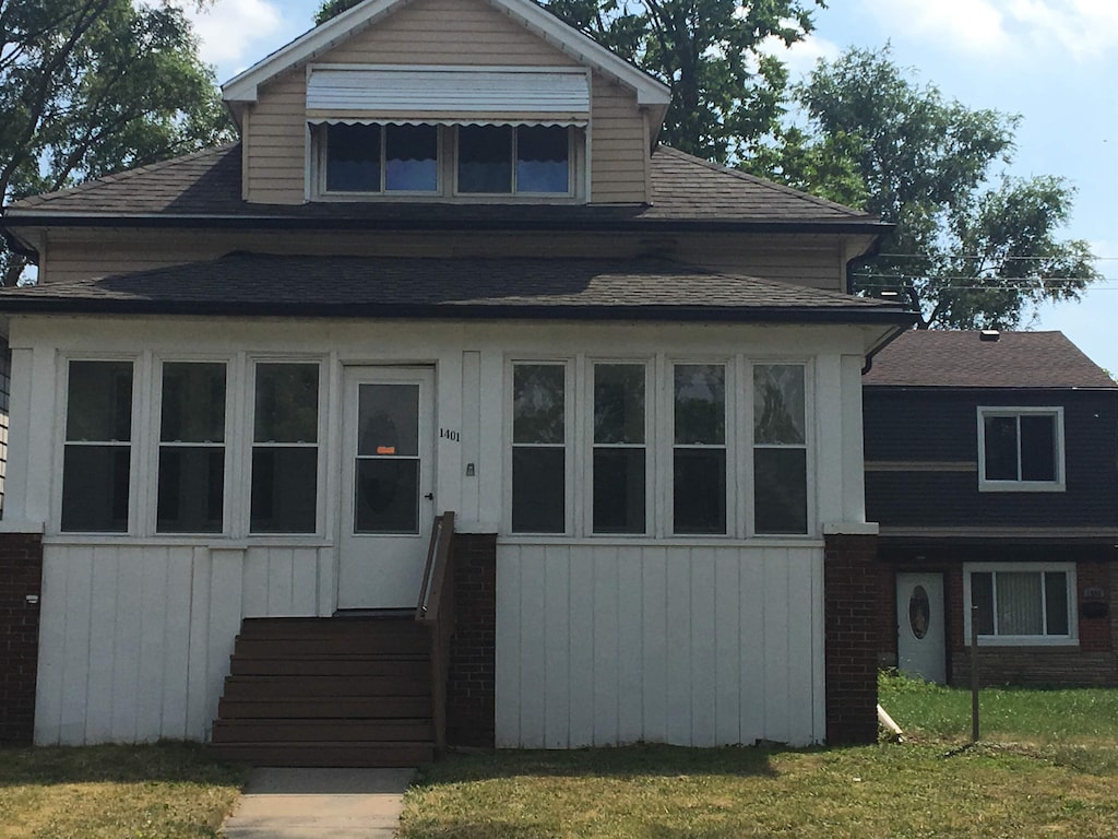 view of front of home with entry steps and a front yard