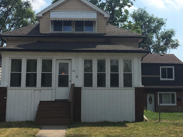 view of front of home with entry steps and a front yard