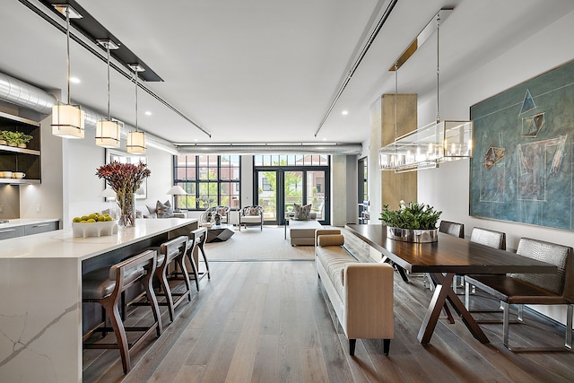 dining room with a chandelier, wood finished floors, and french doors