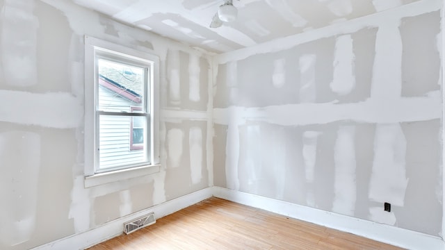 unfurnished room featuring wood finished floors and visible vents