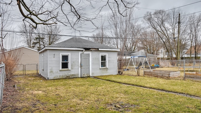 view of outbuilding featuring a garden, a fenced backyard, a playground, and an outbuilding