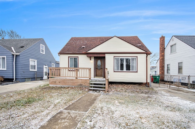 bungalow-style house with roof with shingles, fence, and a deck