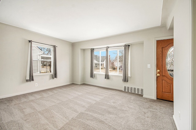 spare room featuring carpet flooring, visible vents, and baseboards