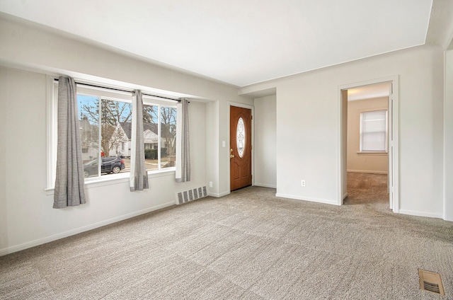 unfurnished room featuring carpet, visible vents, and baseboards