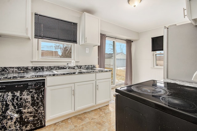 kitchen with black appliances, dark stone countertops, white cabinetry, and a sink