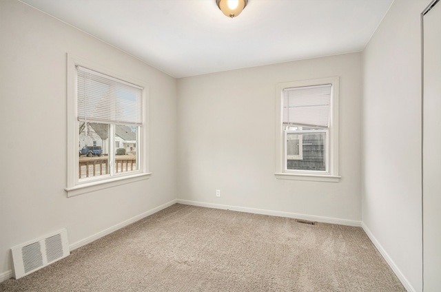 unfurnished room with carpet floors, baseboards, and visible vents