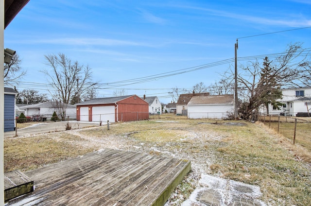 view of yard with an outbuilding, a detached garage, and fence