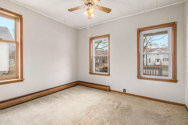 carpeted empty room featuring ornamental molding, a ceiling fan, and baseboards
