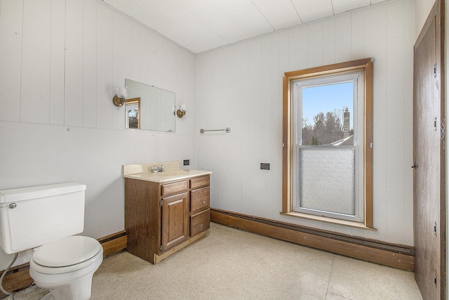 bathroom with toilet, baseboards, and vanity