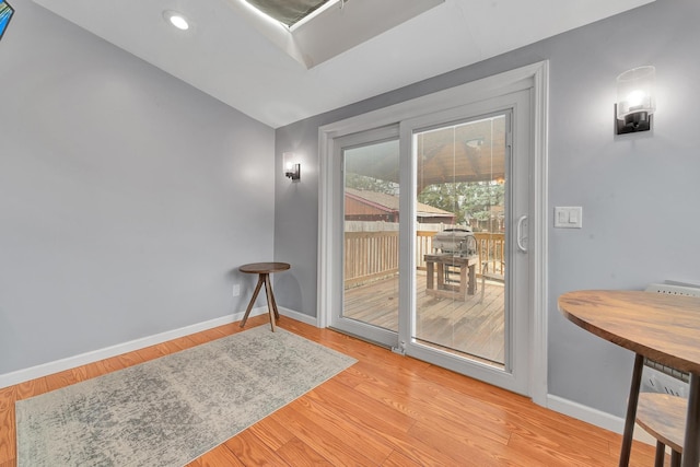 doorway featuring baseboards and wood finished floors