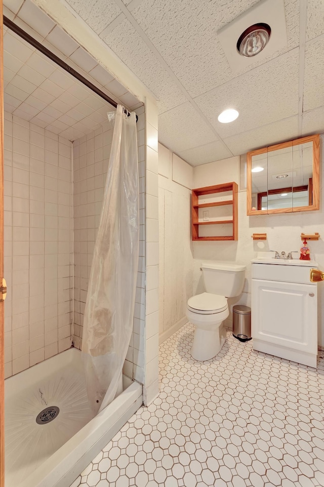 bathroom featuring vanity, a shower stall, toilet, and tile patterned floors